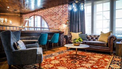 a living room with couches chairs and a piano